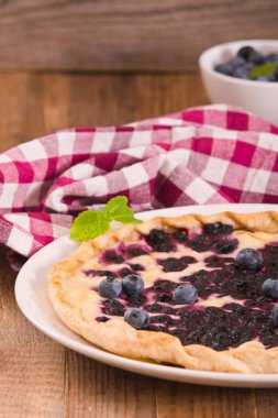 Beyaz çanak üzerinde üzümlü tart. 