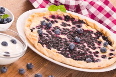 Beyaz çanak üzerinde üzümlü tart. 