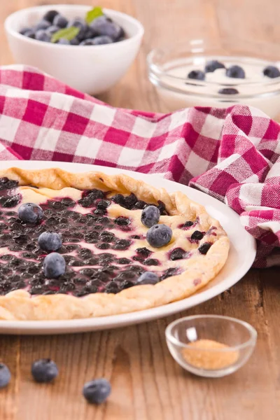 Beyaz çanak üzerinde üzümlü tart. 