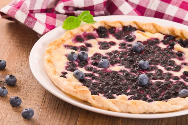 Beyaz çanak üzerinde üzümlü tart. 