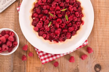 Beyaz çanak üzerinde ahududulu tart. 