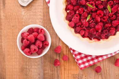 Beyaz çanak üzerinde ahududulu tart. 