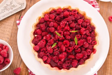 Beyaz çanak üzerinde ahududulu tart. 