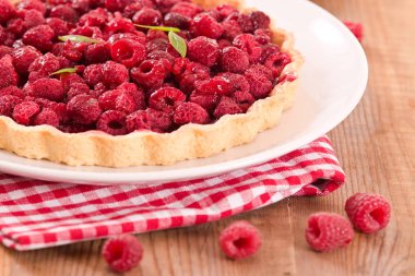 Beyaz çanak üzerinde ahududulu tart. 
