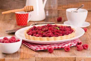 Beyaz çanak üzerinde ahududulu tart. 