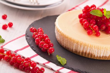Somun cheesecake siyah çanak üzerinde. 