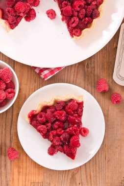 Beyaz çanak üzerinde ahududulu tart. 