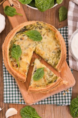 Ispanaklı tart kesme tahtası üzerinde.