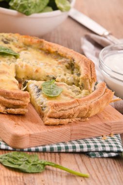 Ispanaklı tart kesme tahtası üzerinde.