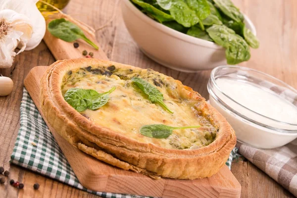 Ispanaklı tart kesme tahtası üzerinde.