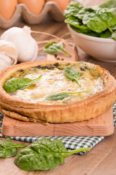 Ispanaklı tart kesme tahtası üzerinde.