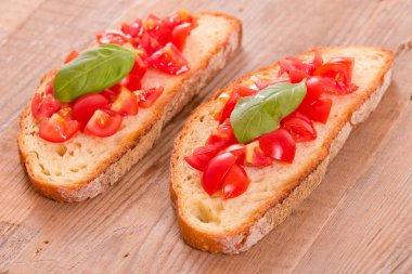 Fesleğen ve doğranmış domates Bruschetta ekmek. 