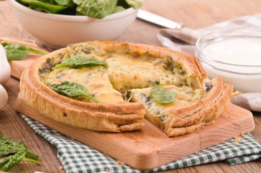 Cuttingboard üzerinde diğer malzemelerle ıspanaklı tart.