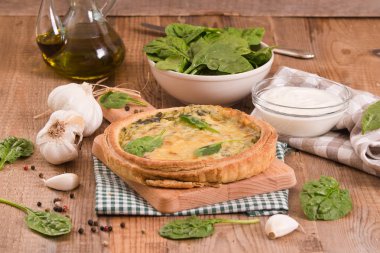 Cuttingboard üzerinde diğer malzemelerle ıspanaklı tart.