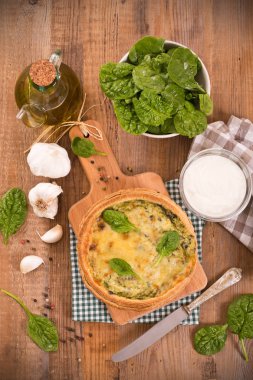 Cuttingboard üzerinde diğer malzemelerle ıspanaklı tart.