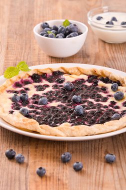 Ahşap masa üzerinde üzümlü tart. 