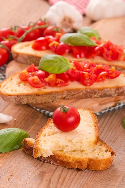 Bruschetta bread with basil and chopped tomatoes. — Stock Photo, Image