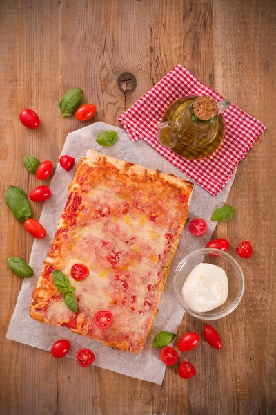 Italian pizza with cheese, tomatoes and fresh basil. — Stock Photo, Image