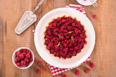 Beyaz çanak üzerinde ahududulu tart. 