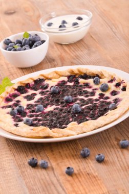 Beyaz çanak üzerinde üzümlü tart. 