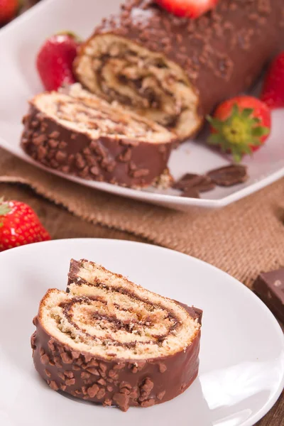 Chocolate roll with hazelnuts and strawberries. — Stock Photo, Image