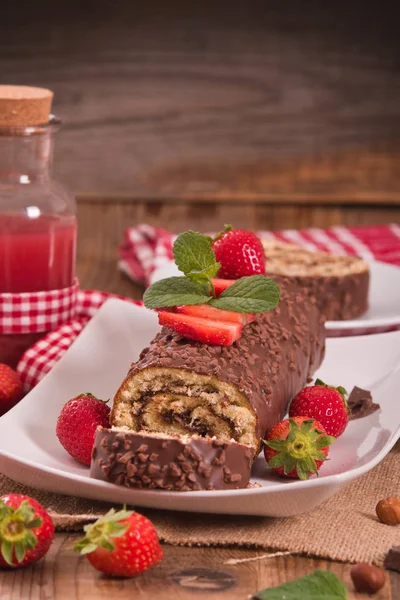 Rolo de chocolate com avelãs e morangos . — Fotografia de Stock