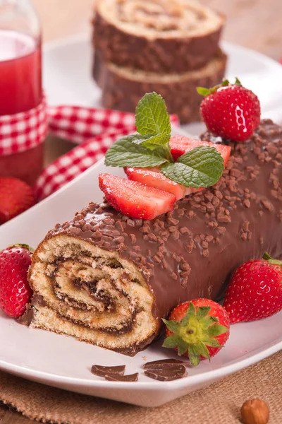 Chocolate roll with hazelnuts and strawberries. — Stock Photo, Image