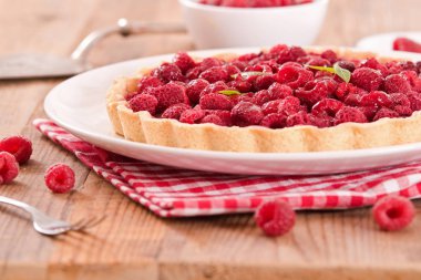 Beyaz çanak üzerinde ahududulu tart. 