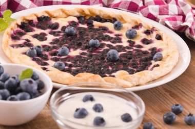 Beyaz çanak üzerinde üzümlü tart. 