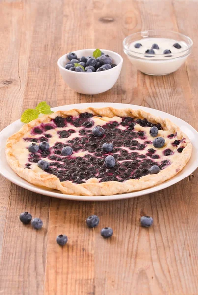 Beyaz çanak üzerinde üzümlü tart. 