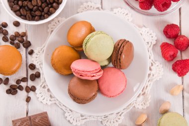 Beyaz çanak üzerinde renkli macarons. 