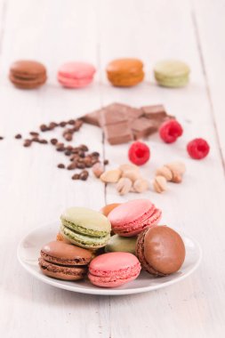 Beyaz çanak üzerinde renkli macarons. 