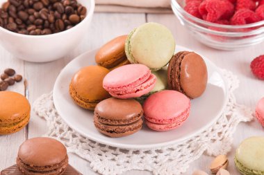 Beyaz çanak üzerinde renkli macarons. 