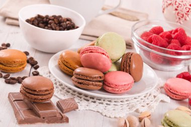 Beyaz çanak üzerinde renkli macarons. 