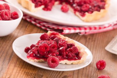 Beyaz çanak üzerinde ahududulu tart. 