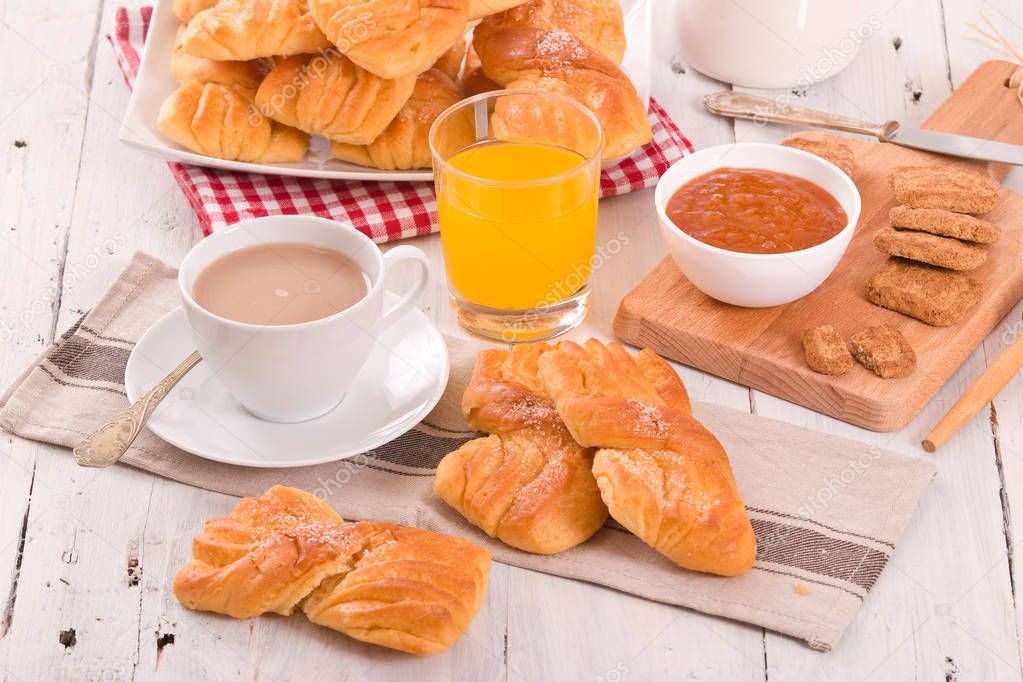 Breakfast with brioches on wooden table. 