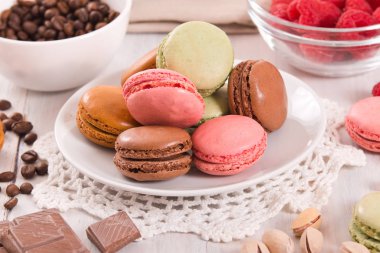 Beyaz çanak üzerinde renkli macarons. 