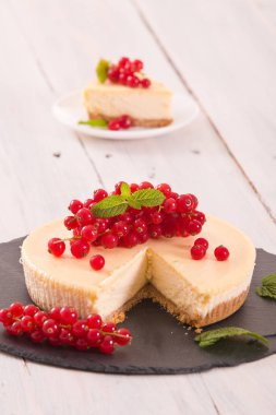 Somun cheesecake siyah çanak üzerinde. 