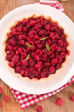 Beyaz çanak üzerinde ahududulu tart. 