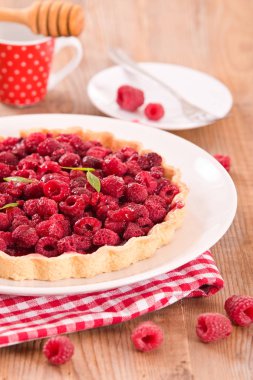 Beyaz çanak üzerinde ahududulu tart. 