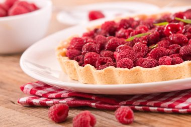 Beyaz çanak üzerinde ahududulu tart. 