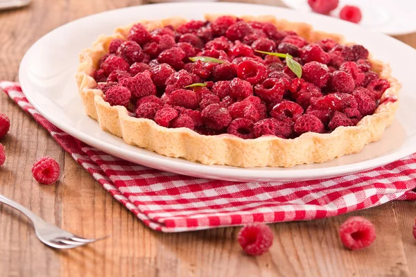 Beyaz çanak üzerinde ahududulu tart. 