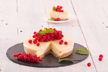 Somun cheesecake siyah çanak üzerinde. 
