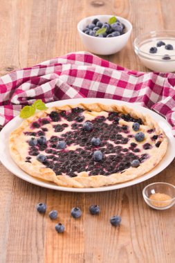 Beyaz çanak üzerinde üzümlü tart. 