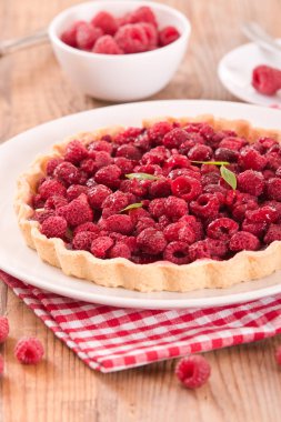 Beyaz çanak üzerinde ahududulu tart. 