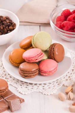 Beyaz çanak üzerinde renkli macarons. 
