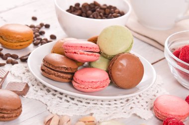 Beyaz çanak üzerinde renkli macarons. 
