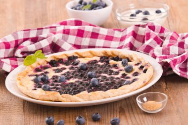 Beyaz çanak üzerinde üzümlü tart. 