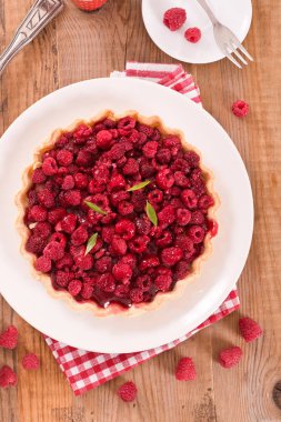 Beyaz çanak üzerinde ahududulu tart. 