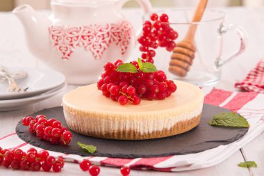 Somun cheesecake siyah çanak üzerinde. 